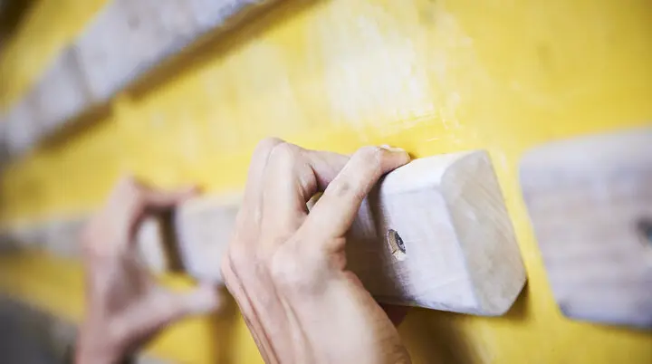 Hände greifen nach Holzelementen an einer Kletterwand | © DAV/Frank Kretschmann